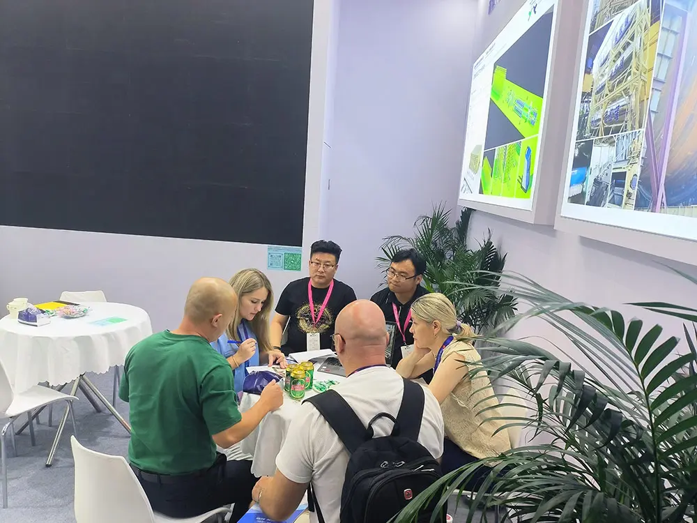 Clientes de Rusia discuten la tecnología y el negocio de la línea de envasado automático para la industria de tableros artificiales en una exposición de carpintería